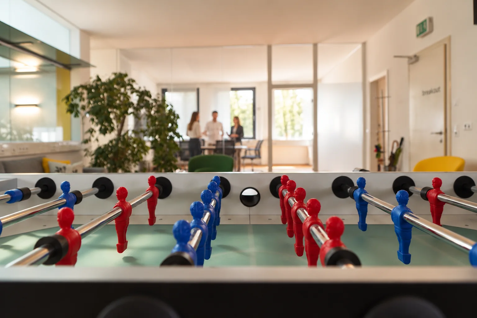 Tischfußballtisch und Mitarbeitende im Break Büro